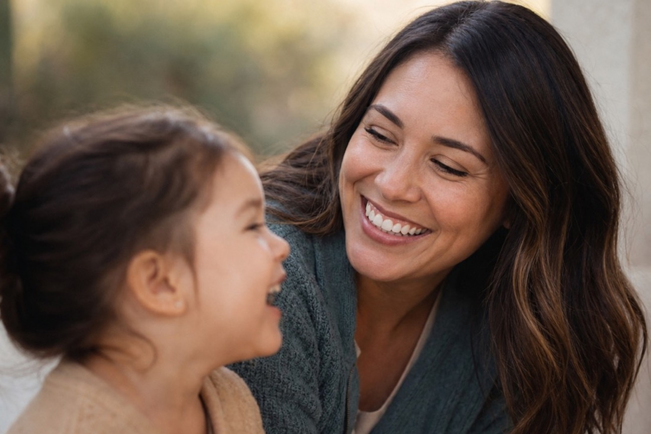 A parent and child laughing together with healthy natural smiles